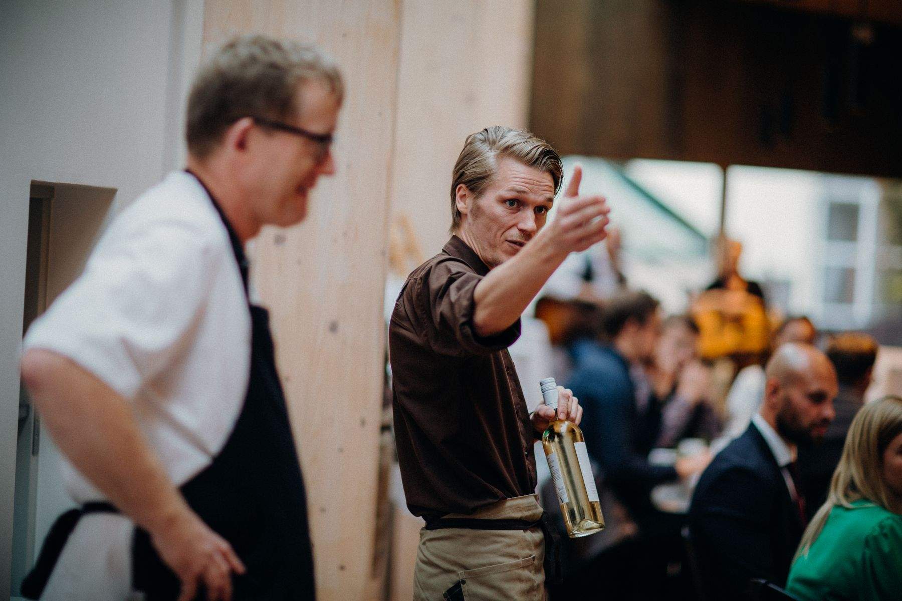 A chef and a front-of-house team member talking on the restaurant floor during service